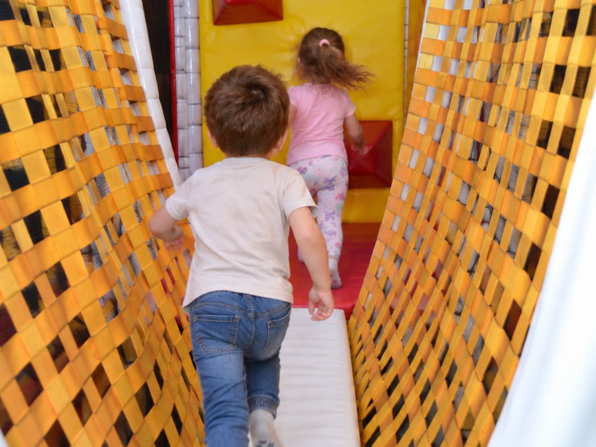 Copii alergând prin coridorul de joacă de la Happy PlayTime Arad