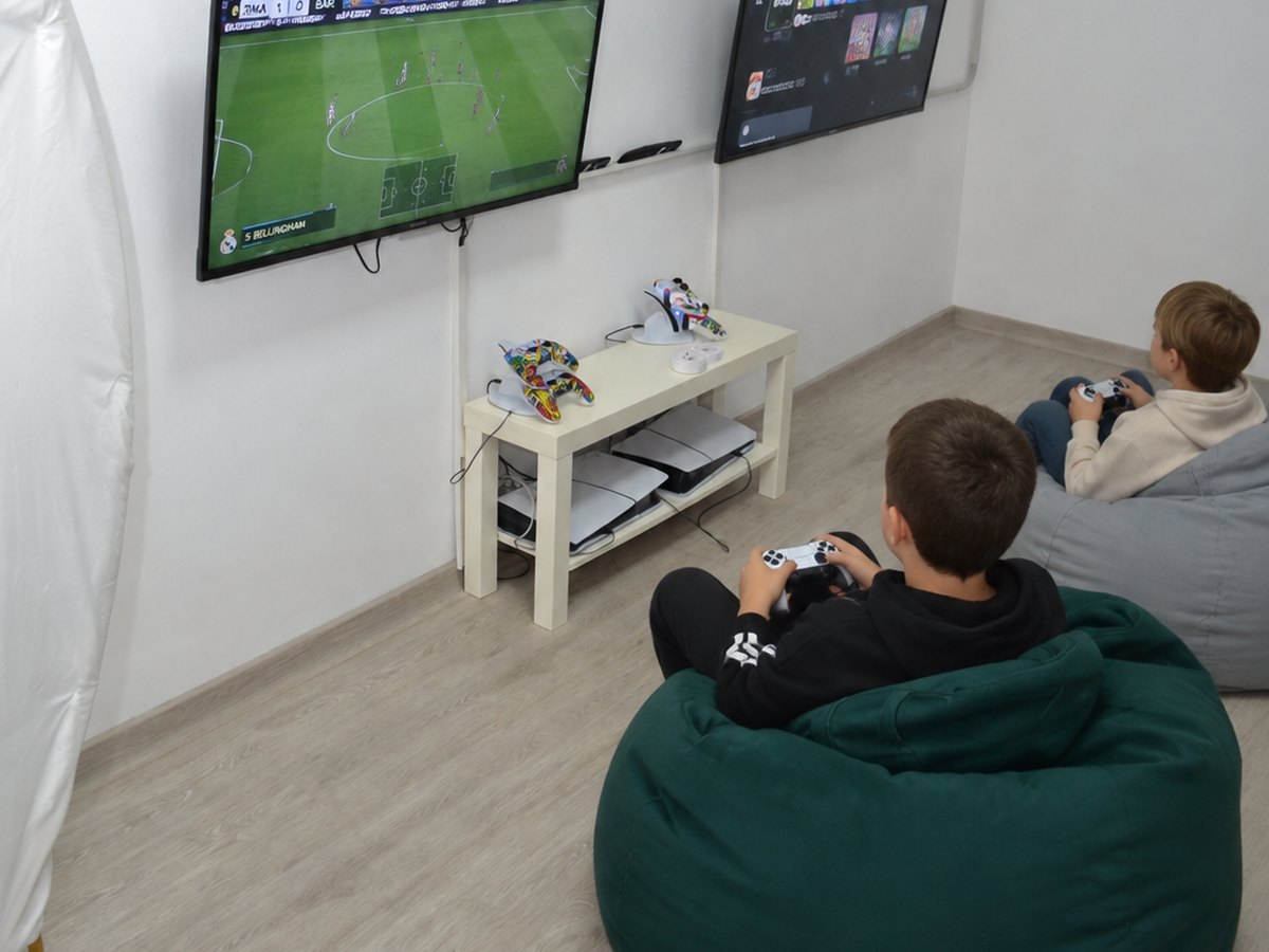 Copii jucând pe PlayStation 5 în sala de gaming de la Happy PlayTime Arad