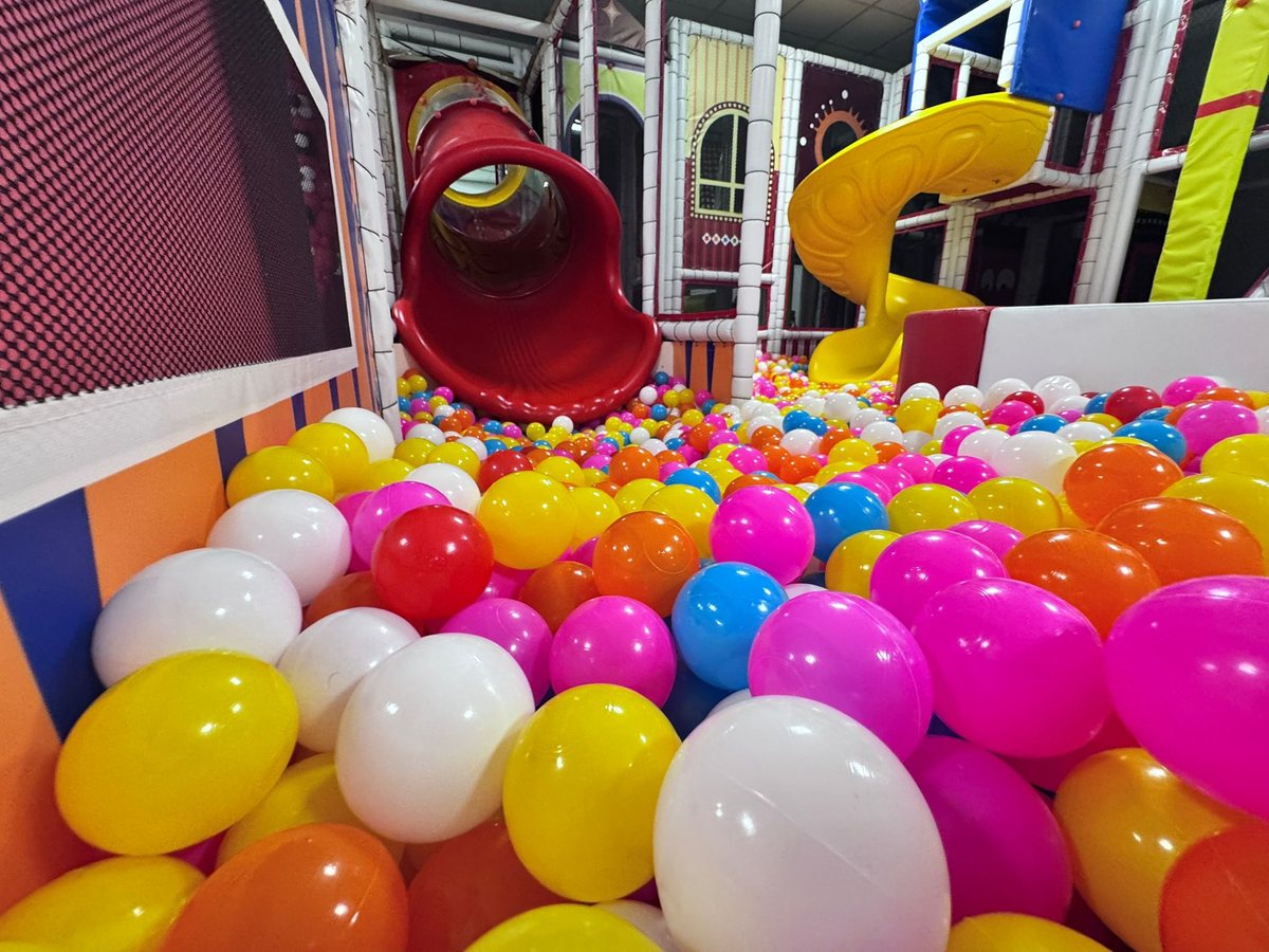 Copil pe tobogan în piscina cu bile